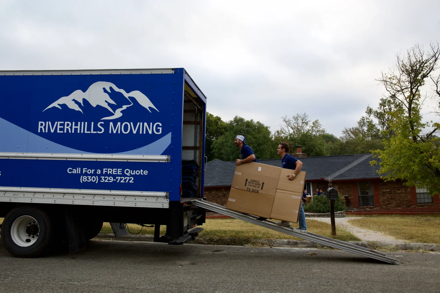 RiverHills Moving crew loading a box into their branded truck