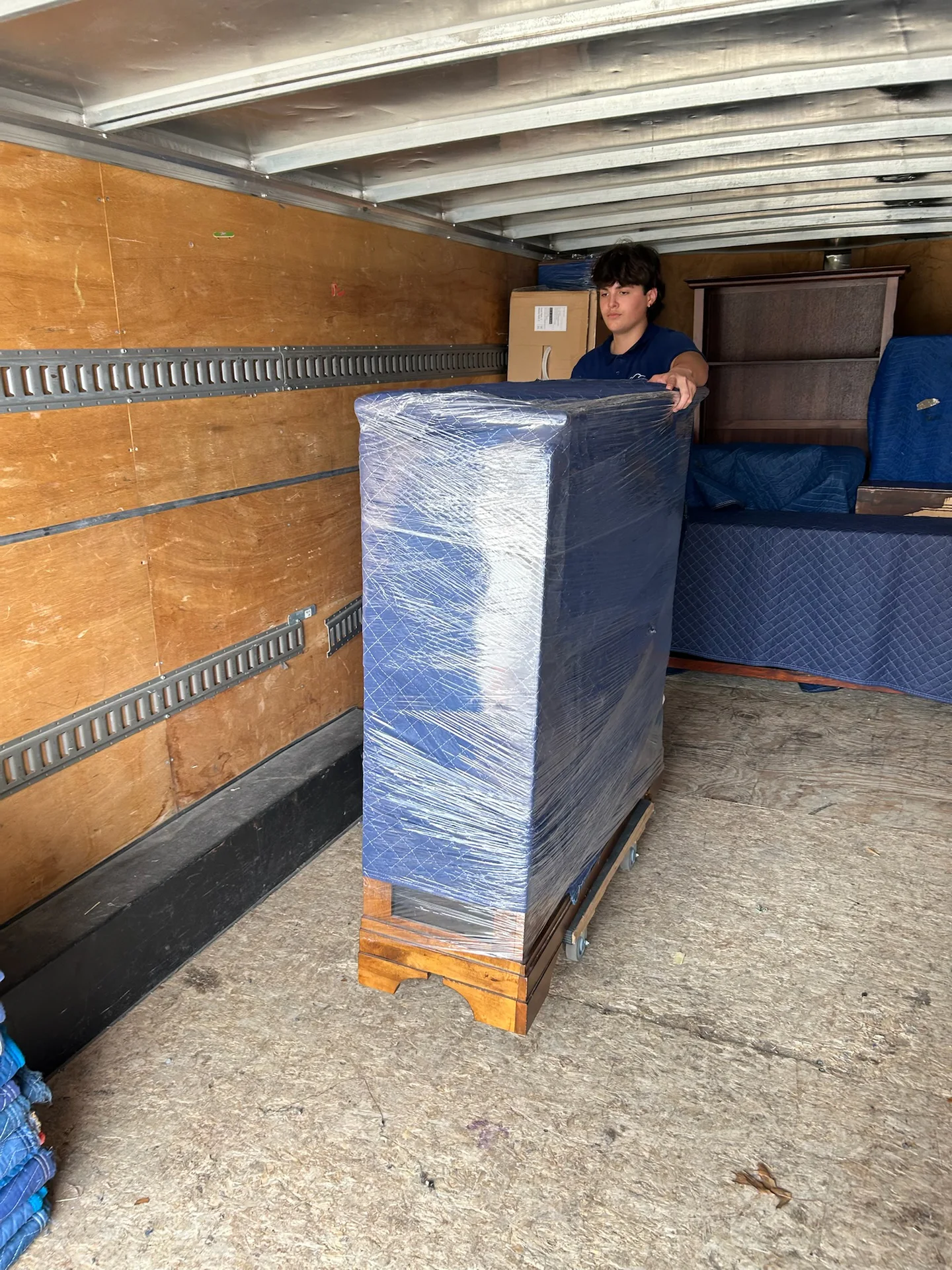 RiverHills Moving crew carrying pad-wrapped furniture